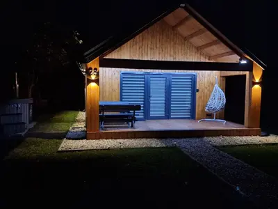 a gazebo with a bench and a blue door at Naujai įrengtas atostogų namelis su kubilu ir pirtimi papildomai in Anykščiai