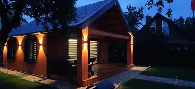 a small wooden house with lights on it at Naujai įrengtas atostogų namelis su kubilu ir pirtimi papildomai in Anykščiai
