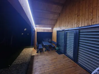 a room with a wooden deck with a table and benches at Naujai įrengtas atostogų namelis su kubilu ir pirtimi papildomai in Anykščiai