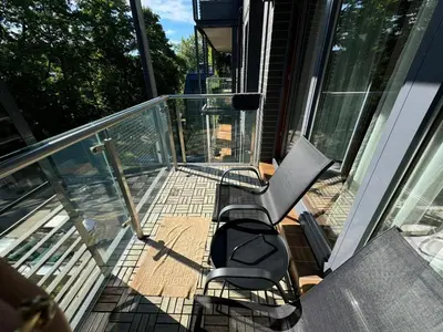 a balcony with two chairs and a bench on a house at Apartamentai prie Kalnų parko in Vilnius