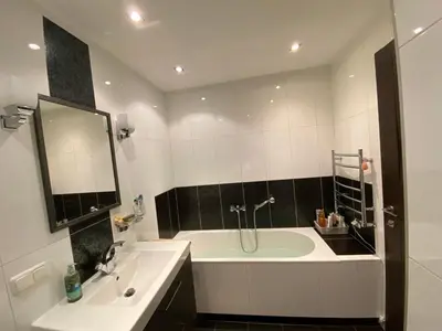 a bathroom with a tub and a sink and a mirror at Apartamentai prie Kalnų parko in Vilnius
