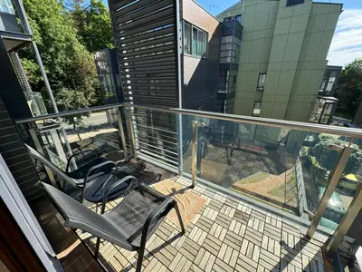 a balcony with two chairs and a view of a building at Apartamentai prie Kalnų parko in Vilnius