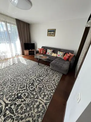 a living room with a couch and a rug at Apartamentai prie Kalnų parko in Vilnius