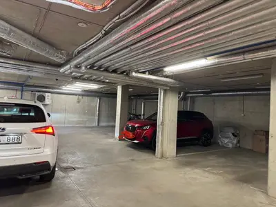 a parking garage with two cars parked in it at Apartamentai prie Kalnų parko in Vilnius