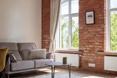 a living room with a couch and a brick wall at Rossak apartment 1 in Panevėžys