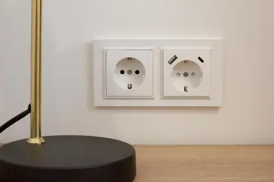 a table with a lamp and two light switches on a wall at Rossak apartment 1 in Panevėžys
