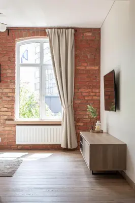 a living room with a brick wall and a window at Rossak apartment 1 in Panevėžys