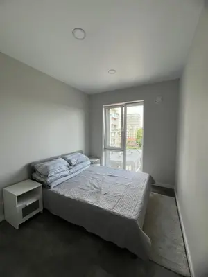 a white bedroom with a bed and a window at Bright and cozy place to stay in Vilnius