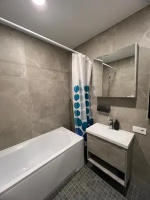 a bathroom with a white tub and a sink and a bath tubermott at Bright and cozy place to stay in Vilnius