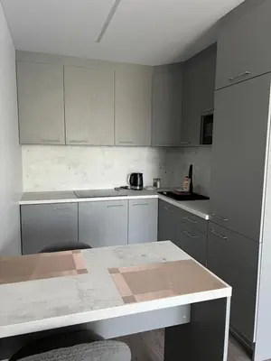 a kitchen with white cabinets and a table in it at Cozy place near old town in Vilnius