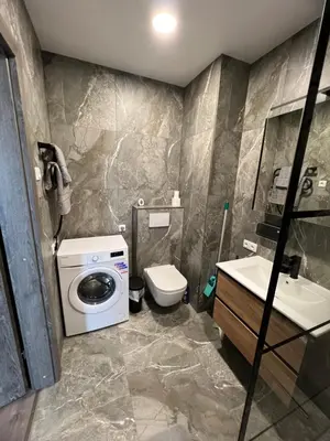 a bathroom with a washing machine and a sink at Cozy place near old town in Vilnius