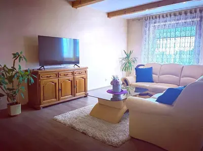 a living room with a couch and a flat screen tv at Lyra cozy large apartment in Šiauliai