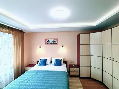 a bedroom with a large bed with blue pillows at Lyra cozy large apartment in Šiauliai