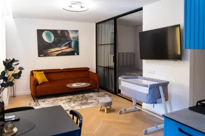 a living room with a couch and a table at SongInn Lake Apartment in Zarasai