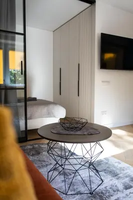 a coffee table in a room with a bedroom at SongInn Lake Apartment in Zarasai