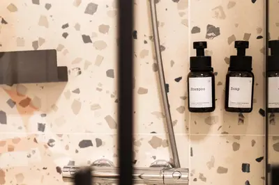 a bathroom with two bottles of essential oils on a mirror at SongInn Lake Apartment in Zarasai