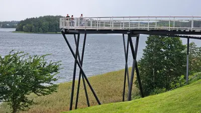 people standing on a bridge over a body of water at SongInn Lake Apartment in Zarasai