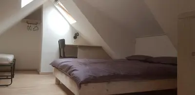 a bedroom with a bed in a attic at Jaukūs namai Kulautuvoje in Kulautuva