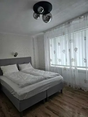 a bedroom with a bed and a large window at Suncity 2 apartamentai in Šiauliai