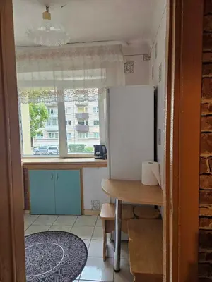 a kitchen with a table and a white refrigerator at Suncity 2 apartamentai in Šiauliai