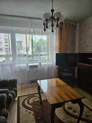 a living room with a wooden table and a television at Suncity 2 apartamentai in Šiauliai