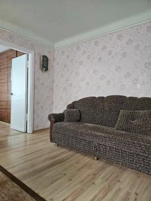 a living room with a brown couch in a room at Suncity 2 apartamentai in Šiauliai