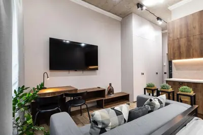 a living room with a couch and a tv on a wall at Renaissance Apartments by Reside Baltic in Vilnius