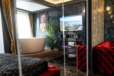 a bedroom with a tub and a tv and a bed at AMJ Royal Apartments - 115 - Black Rubby in Kaunas