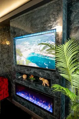 a flat screen tv sitting on a wall with a aquarium at AMJ Royal Apartments - 115 - Black Rubby in Kaunas