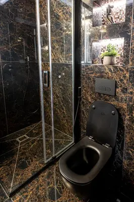 a bathroom with a black toilet and a shower at AMJ Royal Apartments - 115 - Black Rubby in Kaunas