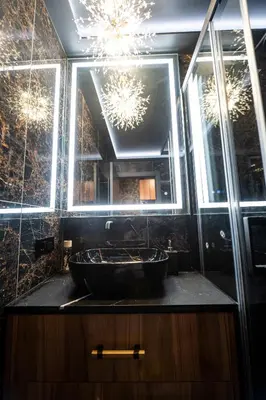 a bathroom with a black sink and a chandelier at AMJ Royal Apartments - 115 - Black Rubby in Kaunas