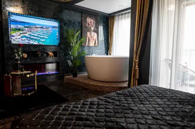 a bedroom with a bath tub and a tv in a room at AMJ Royal Apartments - 115 - Black Rubby in Kaunas