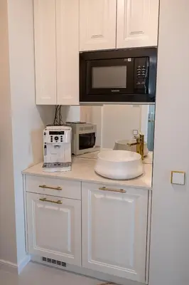 a kitchen with white cabinets and a microwave at AMJ Royal Apartments - 120 - Royal Classic in Kaunas