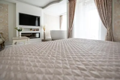 a bedroom with a large bed and a television at AMJ Royal Apartments - 120 - Royal Classic in Kaunas