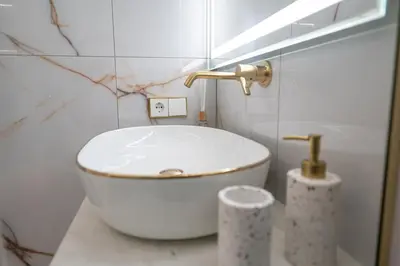 a bathroom with a white tub and a sink at AMJ Royal Apartments - 120 - Royal Classic in Kaunas