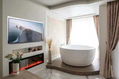 a bathroom with a large tub and a fireplace at AMJ Royal Apartments - 120 - Royal Classic in Kaunas