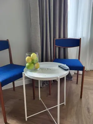 a table with a bowl of fruit and two chairs at Greenhill Trio in Kaunas