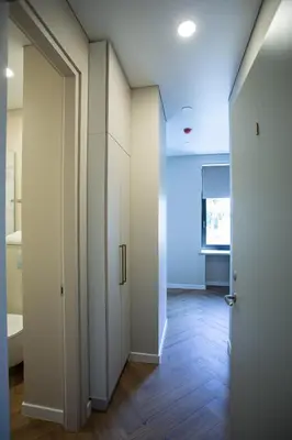 a hallway with white doors and wood floors at Greenhill Trio in Kaunas
