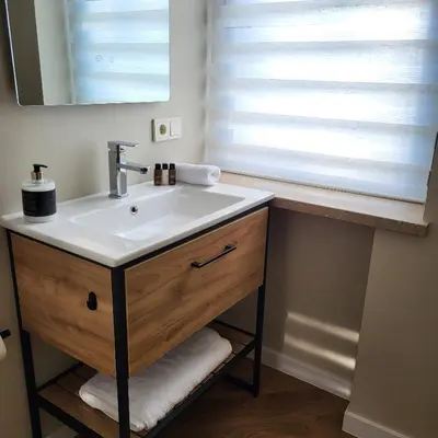 a bathroom sink with a mirror and a window at Greenhill Trio in Kaunas