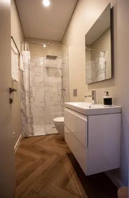 a bathroom with a white sink and a shower at Greenhill Trio in Kaunas