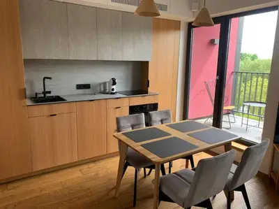 a kitchen with a table and chairs in a room at Sunny Cosy Home in Kaunas