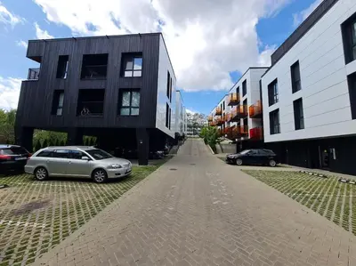 a street with two cars parked in front of buildings at Sunny Cosy Home in Kaunas