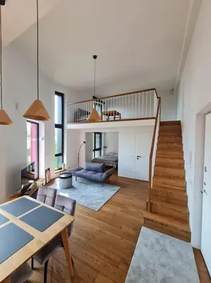 a living room with a dining table and a staircase at Sunny Cosy Home in Kaunas