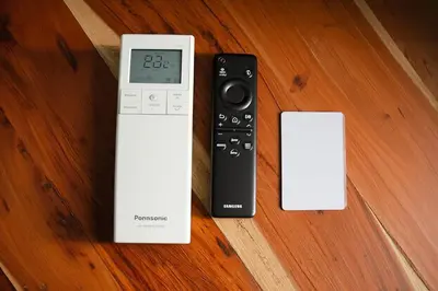 a remote control sitting on top of a wooden table at Cozy Family Apartments in Druskininkai