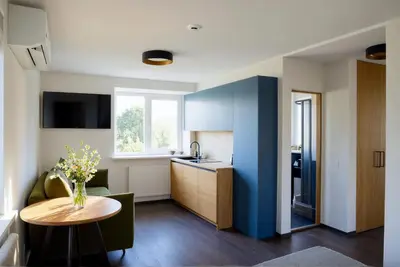 a living room with a table and a kitchen at Cozy Family Apartments in Druskininkai