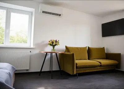 a living room with a couch and a table with flowers at Cozy Family Apartments in Druskininkai