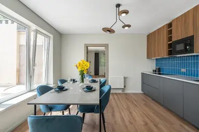a kitchen and dining room with a table and chairs at Central Park Apartments in Birštonas