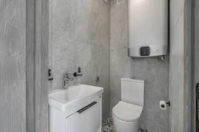 a bathroom with a white sink and a toilet at Central Park Apartments in Birštonas