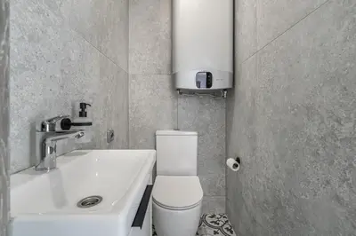 a bathroom with a white toilet and a sink at Central Park Apartments in Birštonas