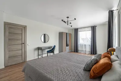 a bedroom with a large bed and a desk at Central Park Apartments in Birštonas